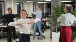 Four office workers warm up during a break. Employees do fitness exercises at the workplace