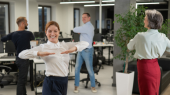 Four office workers warm up during a break. Employees do fitness exercises at the workplace