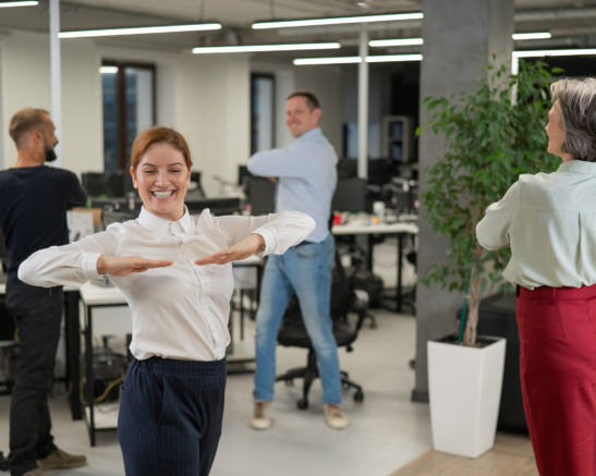Four office workers warm up during a break. Employees do fitness exercises at the workplace