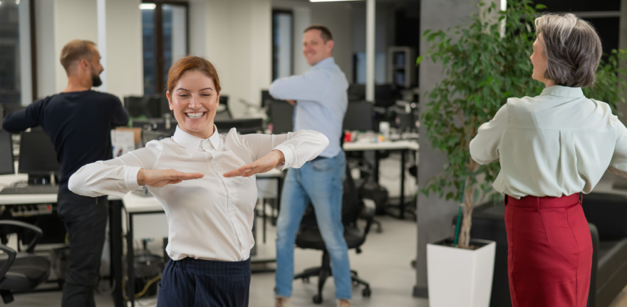 Four office workers warm up during a break. Employees do fitness exercises at the workplace